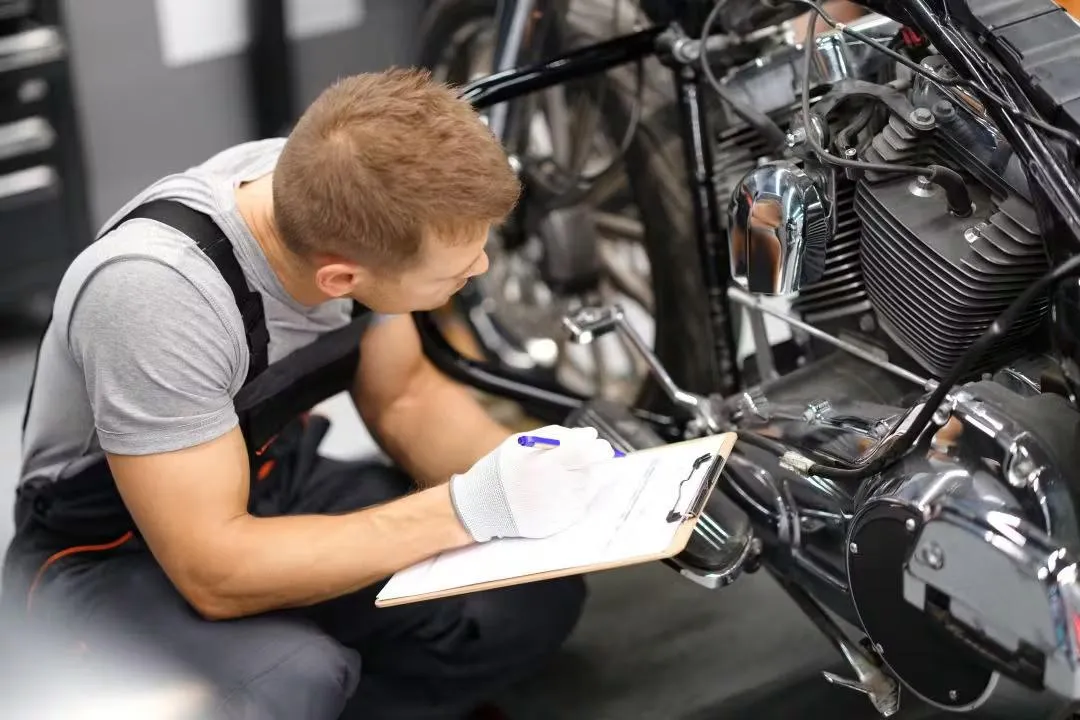 a black and white photo of a man working on a motorcycle