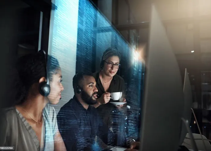 "Customer support team working at their computers in a call center environment"