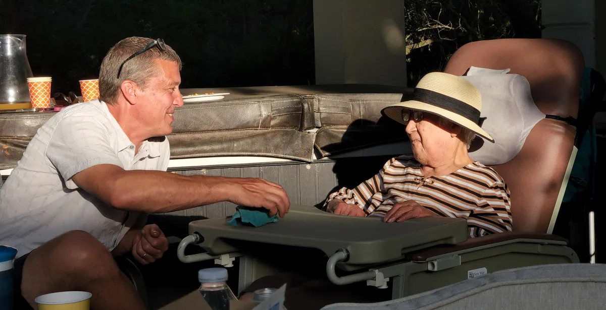 Caregiver assisting a senior resident in a personalized, home-like environment.