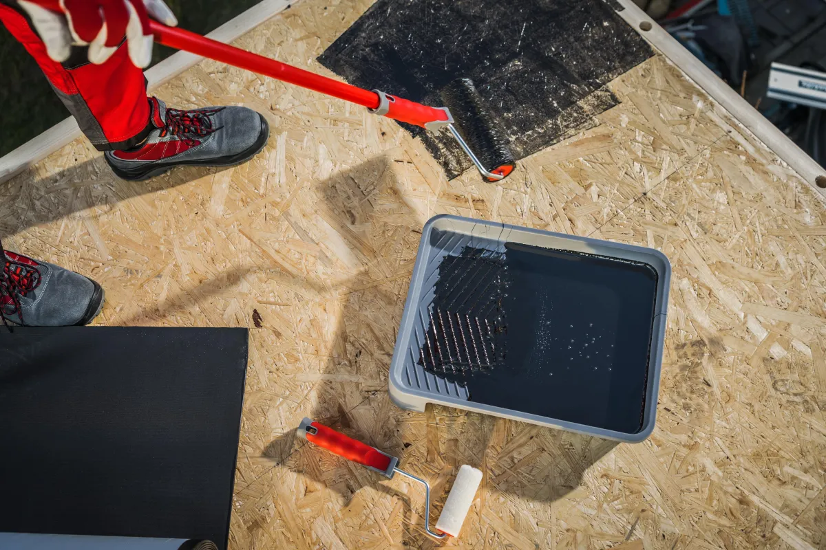 worker-priming-plywood-roof-before-epdm-membrane