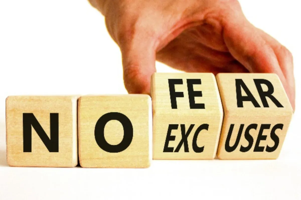 Hand placing wooden blocks to read no fear/excuses