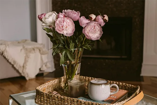 roses and coffee on a tray by a fireplace