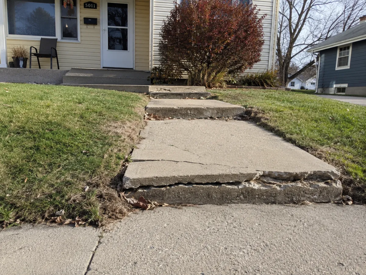 cracked front walkway and steps leading to trip hazard