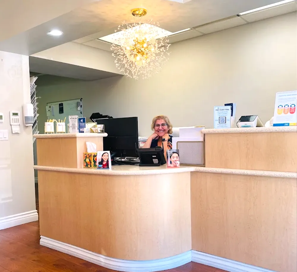 Dental Receptionist smiling behind desk