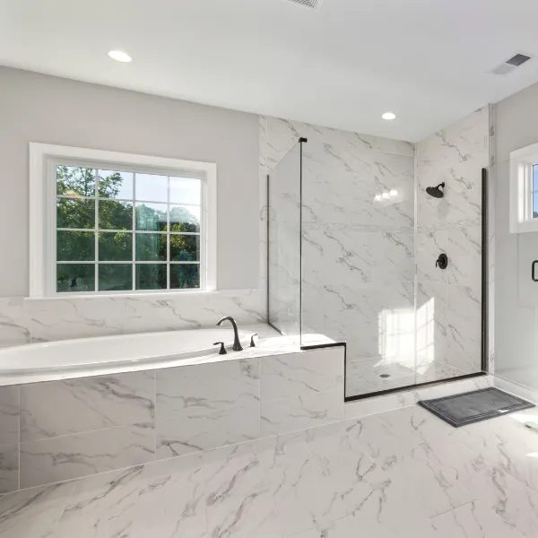 Double vanity bathroom renovation with navy blue cabinets round mirrors and modern lighting