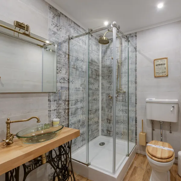 Full bathroom renovation with glass vessel sink marble countertop and compact walk-in shower