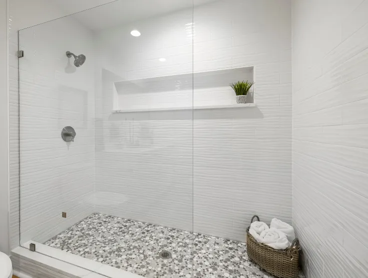 Modern walk-in shower remodel with white tile walls and built-in shelving in Maryland home