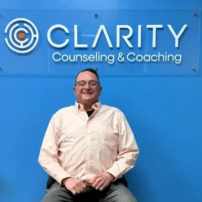 Professional headshot of Jason Thomas, Executive Director of Operations, smiling in a white dress shirt with glasses, set against a solid blue background.