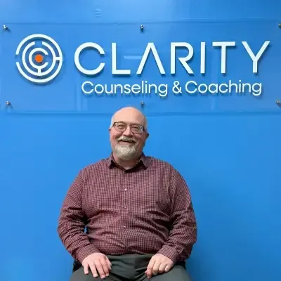 Professional headshot of Christopher VanStee, Executive Director of Clinical Services, smiling warmly in a blue collared shirt against a clean studio background.