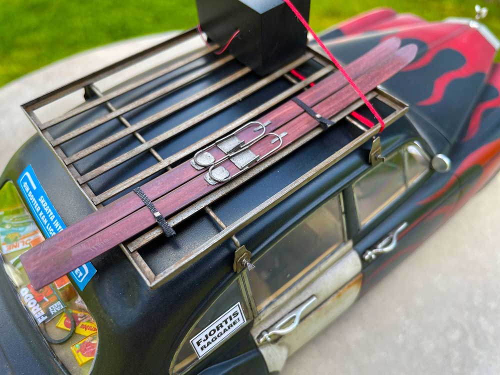 a par of skies on he roof of a rolls royce 