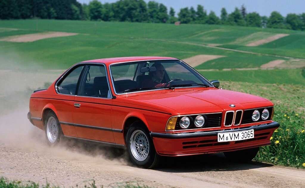 red bmw 635 csi on a dirty road 