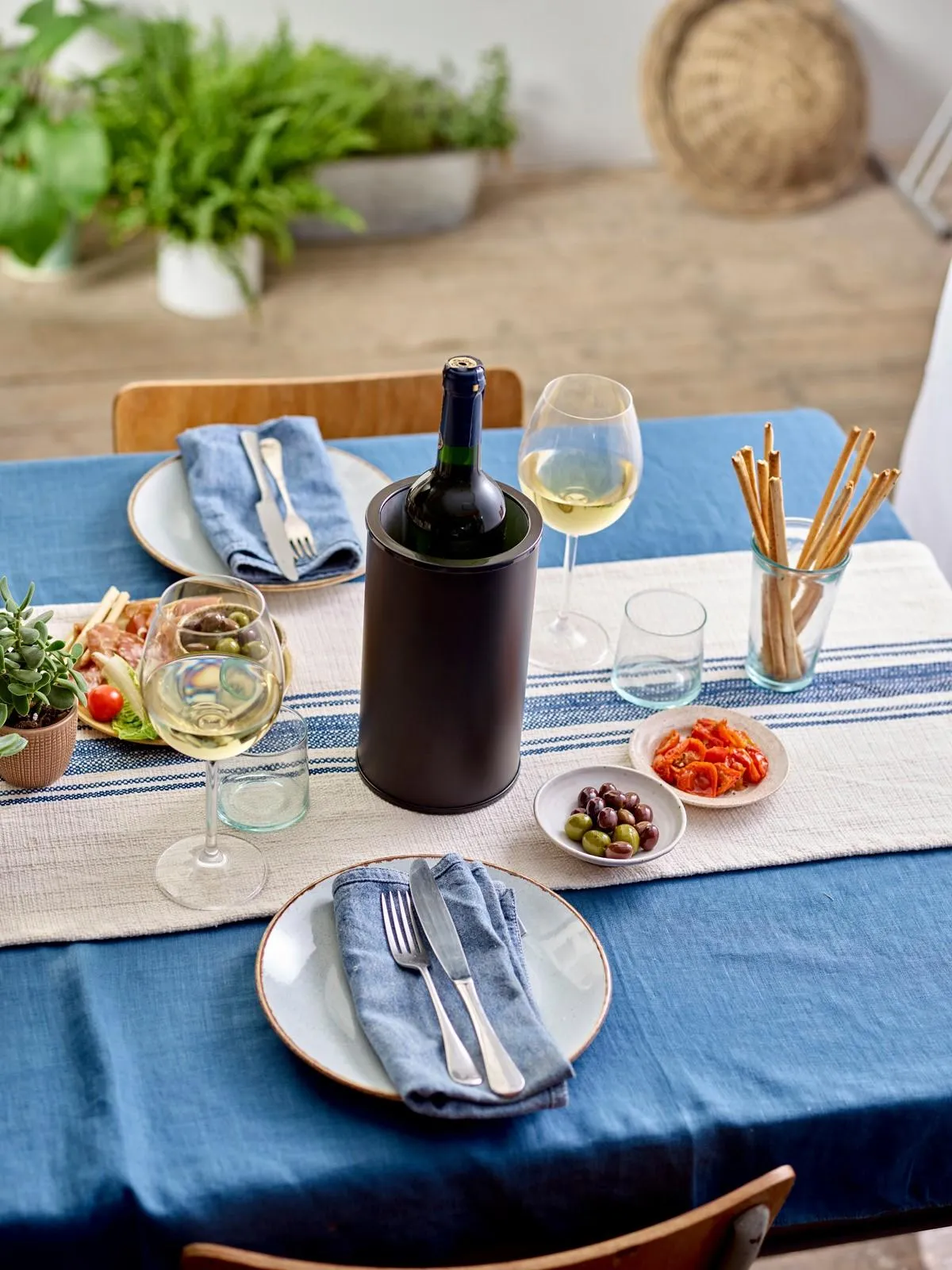 Wine Cooler with wine bottle in it sitting on a table with a Mediterranean food spread