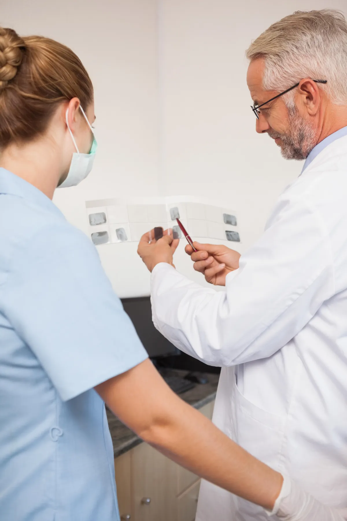 a dentist holding a dental tool over a person's mouth