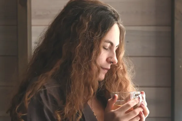 Woman in her 40s holding a mug, representing calming the nervous system for better gut health in perimenopause