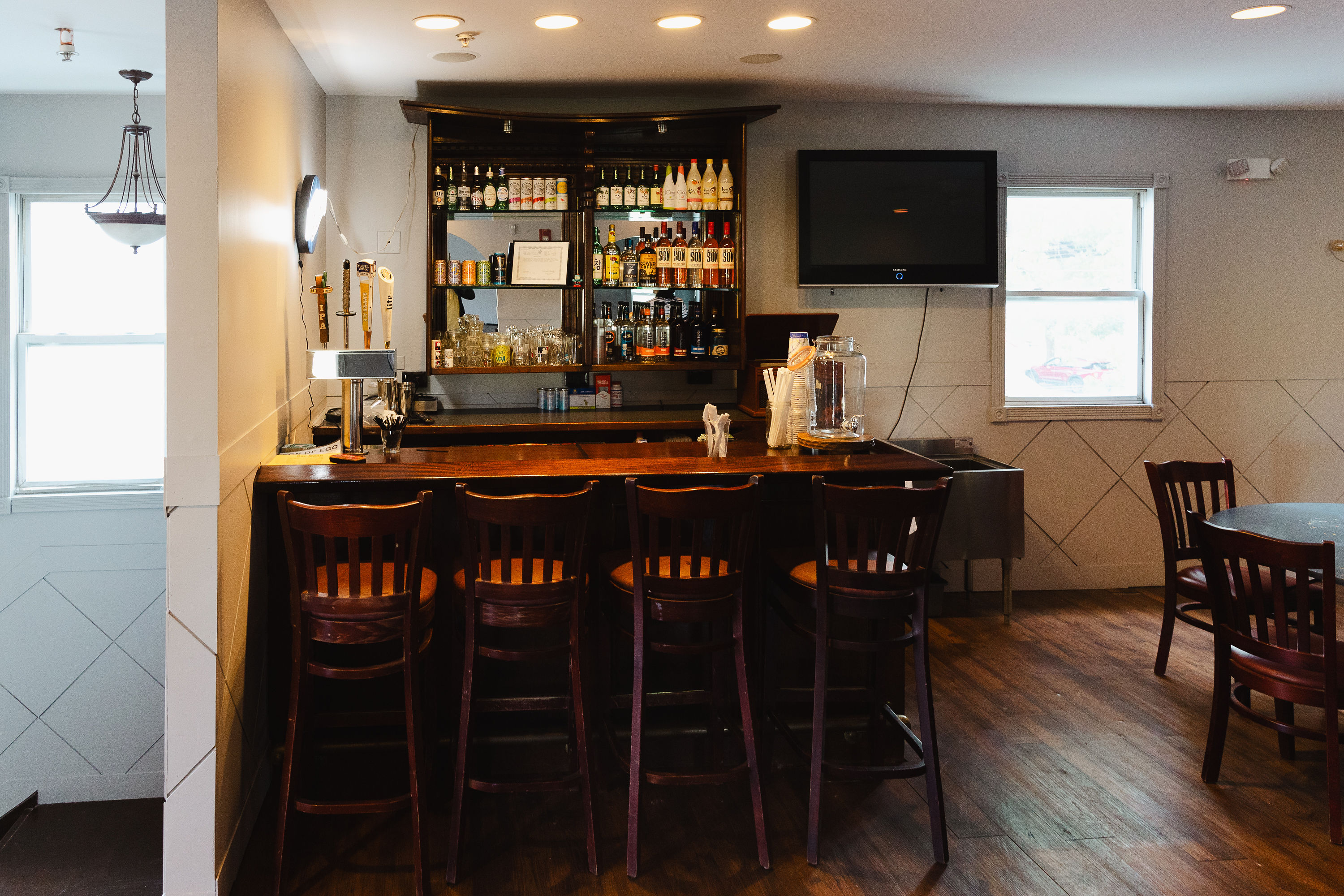 The upstairs bar with full shelves and a TV