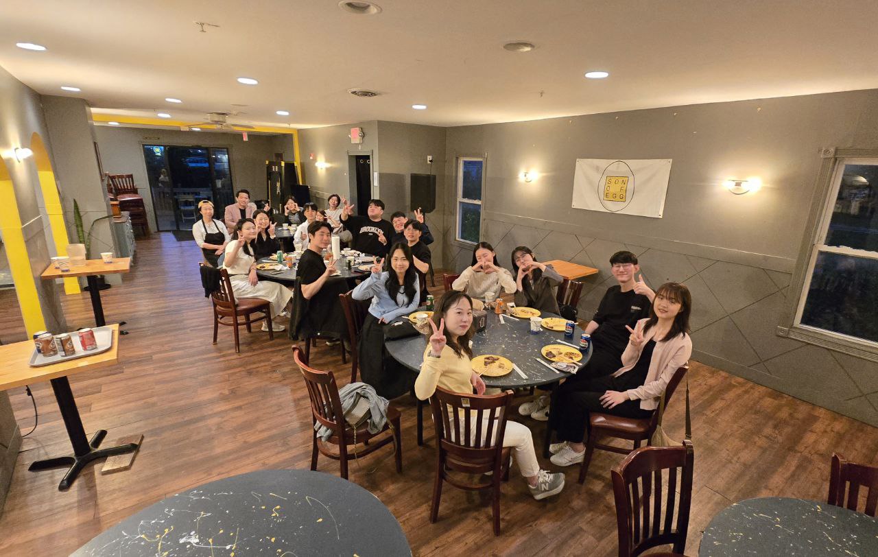 A full room of guests at round tables upstairs at Son of Egg