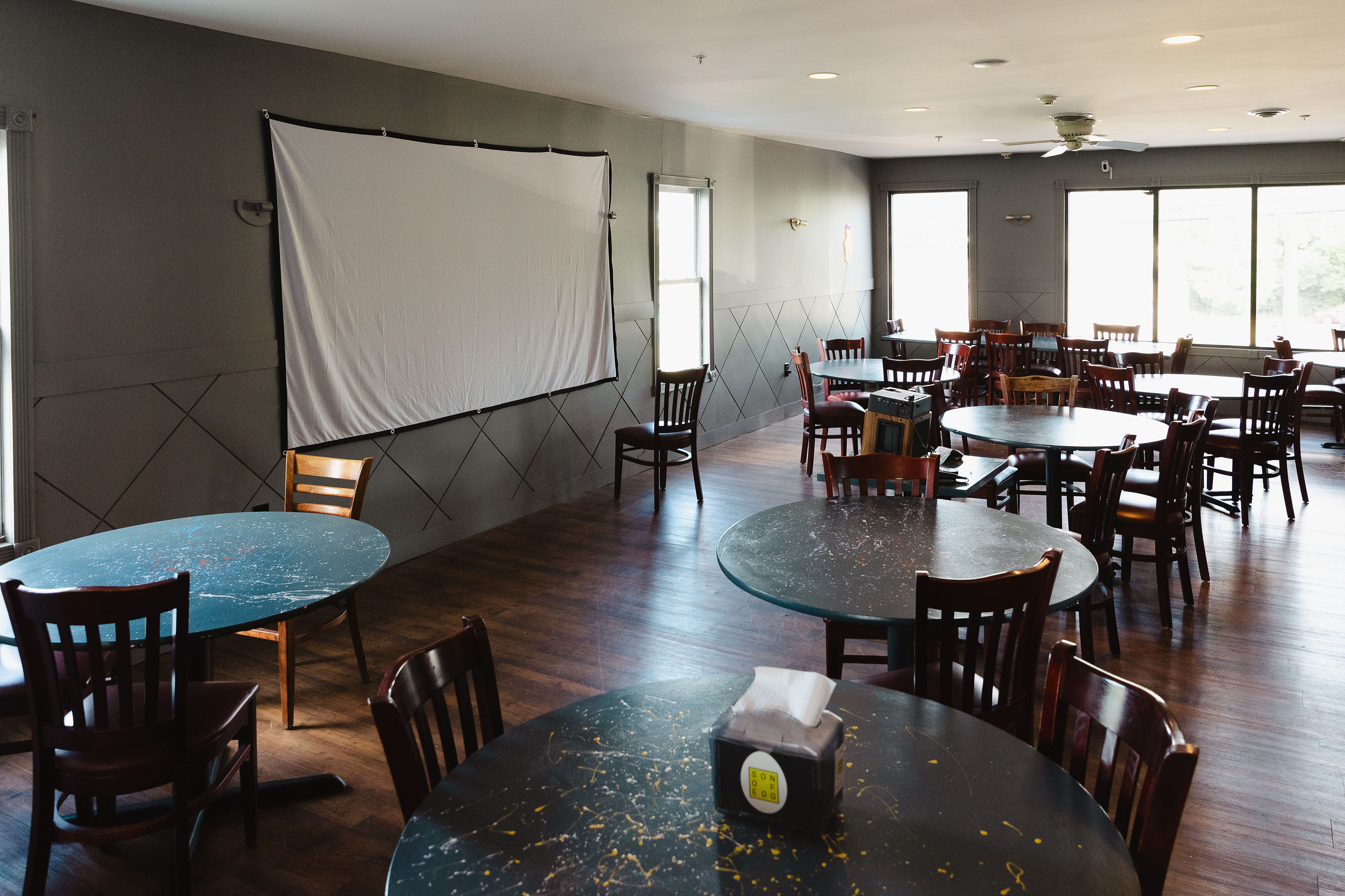 Big projector screen on the wall with the room set up