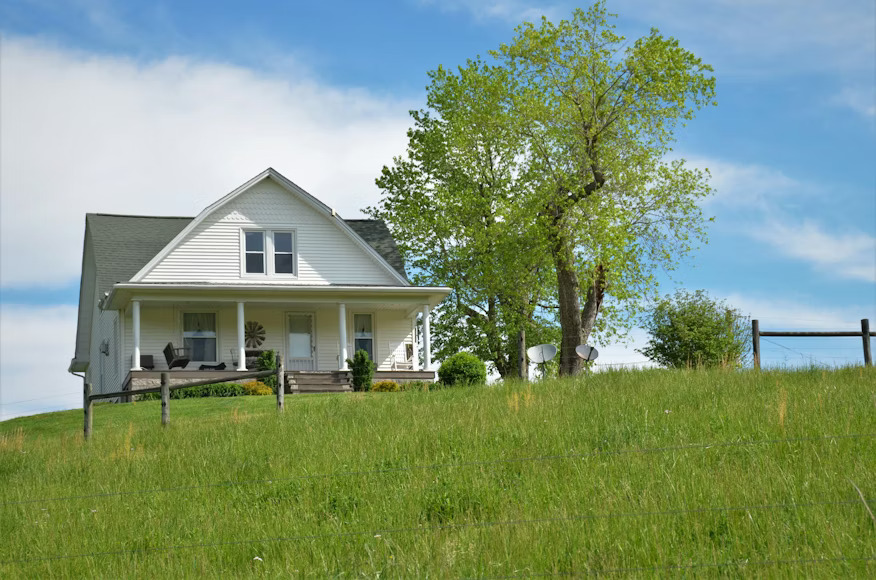A brick building with a conical roof and white windows.