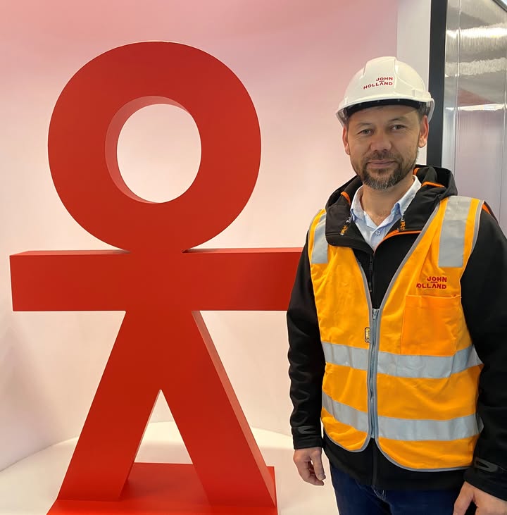 CareerSeekers' participant posing in front of John Holland logo during their workplace placement