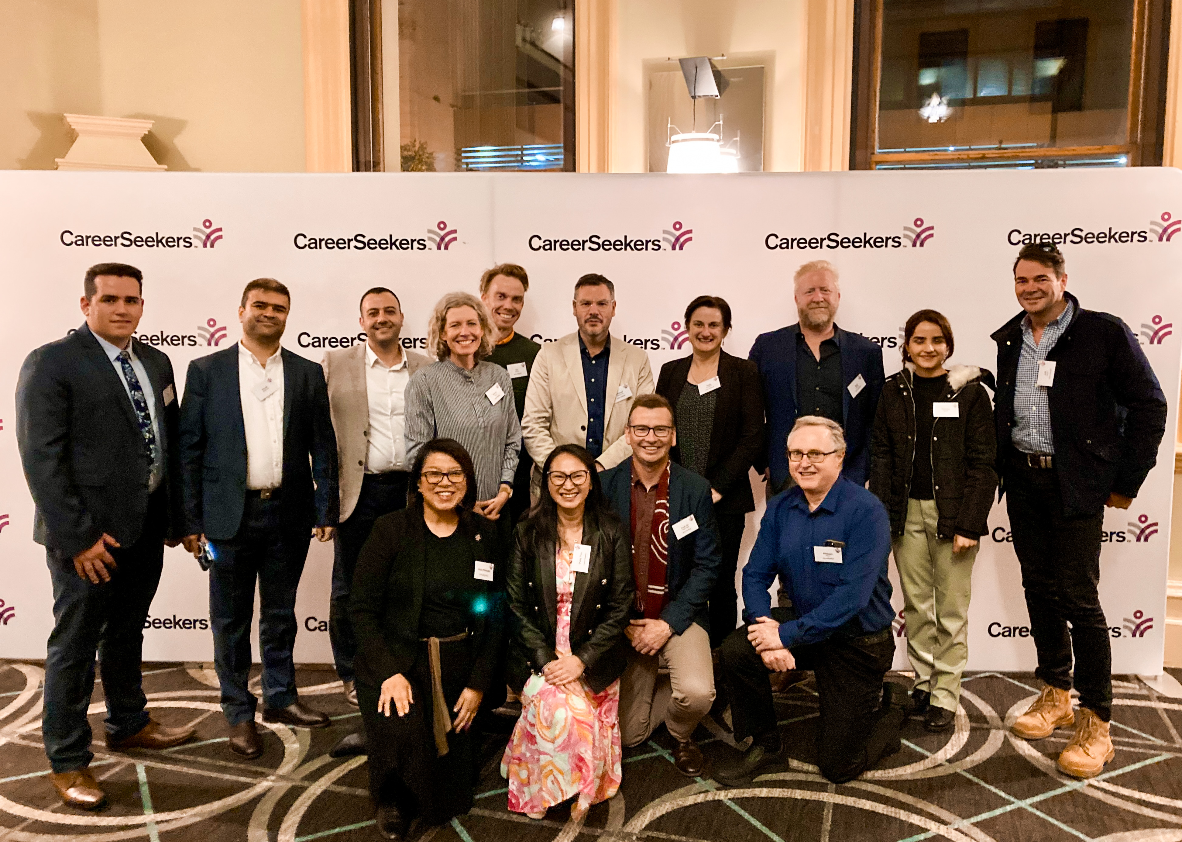 A large group photo in front of a backdrop at a CareerSeekers Spotlight event
