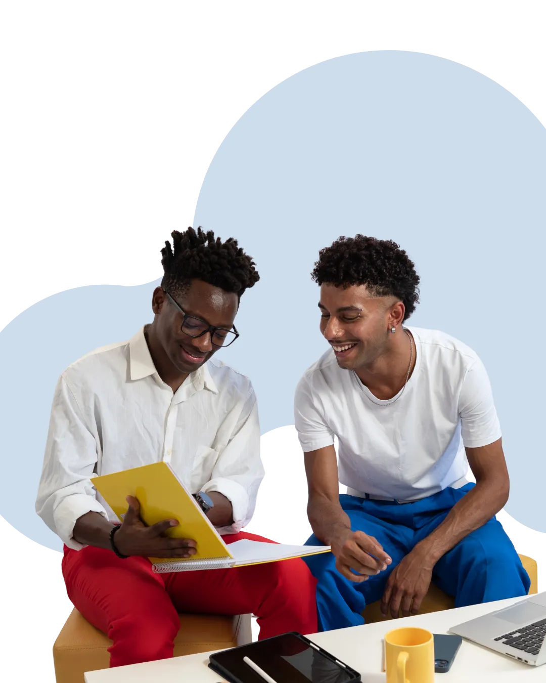Two young professionals sitting together, reviewing notes during a casual conversation