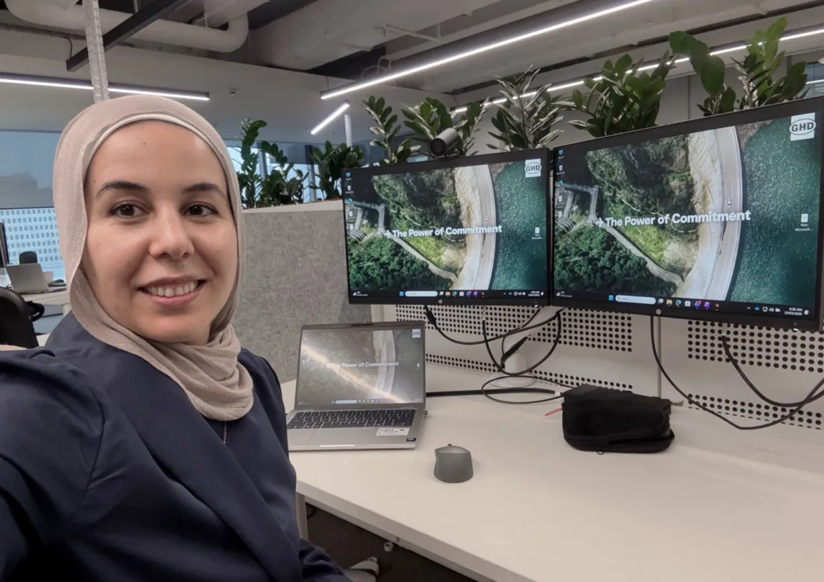 A CareerSeekers participant taking a selfie at her workstation with multiple monitors