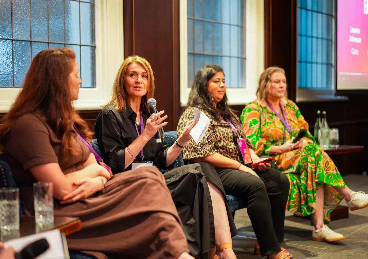 A panel of four women at a CareerSeekers Leadership Development Institute (LDI) event seated together, one speaking into a microphone