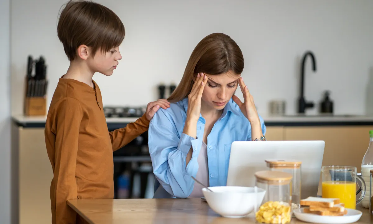 Stressed mom with child at breakfast table, feeling overwhelmed before IEP or 504 meeting preparation.