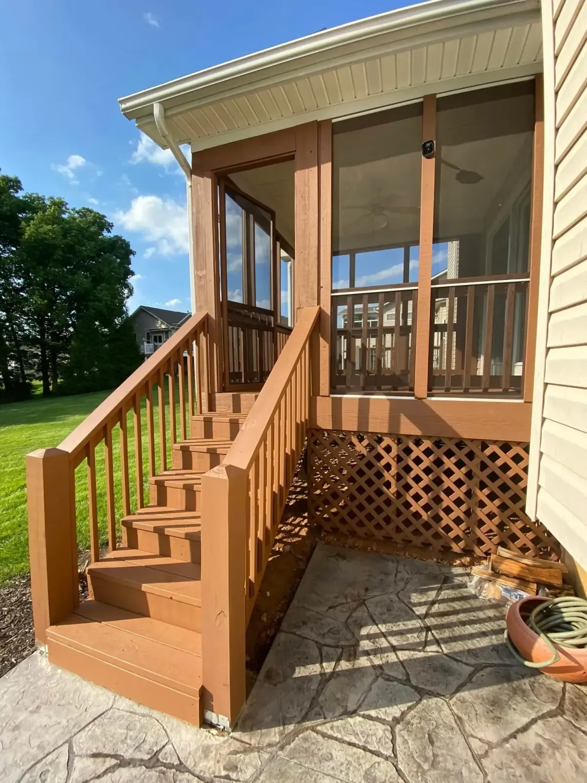 Freshly stained wooden deck and stairway leading to screened porch in St. Peters, MO – home exterior improvement