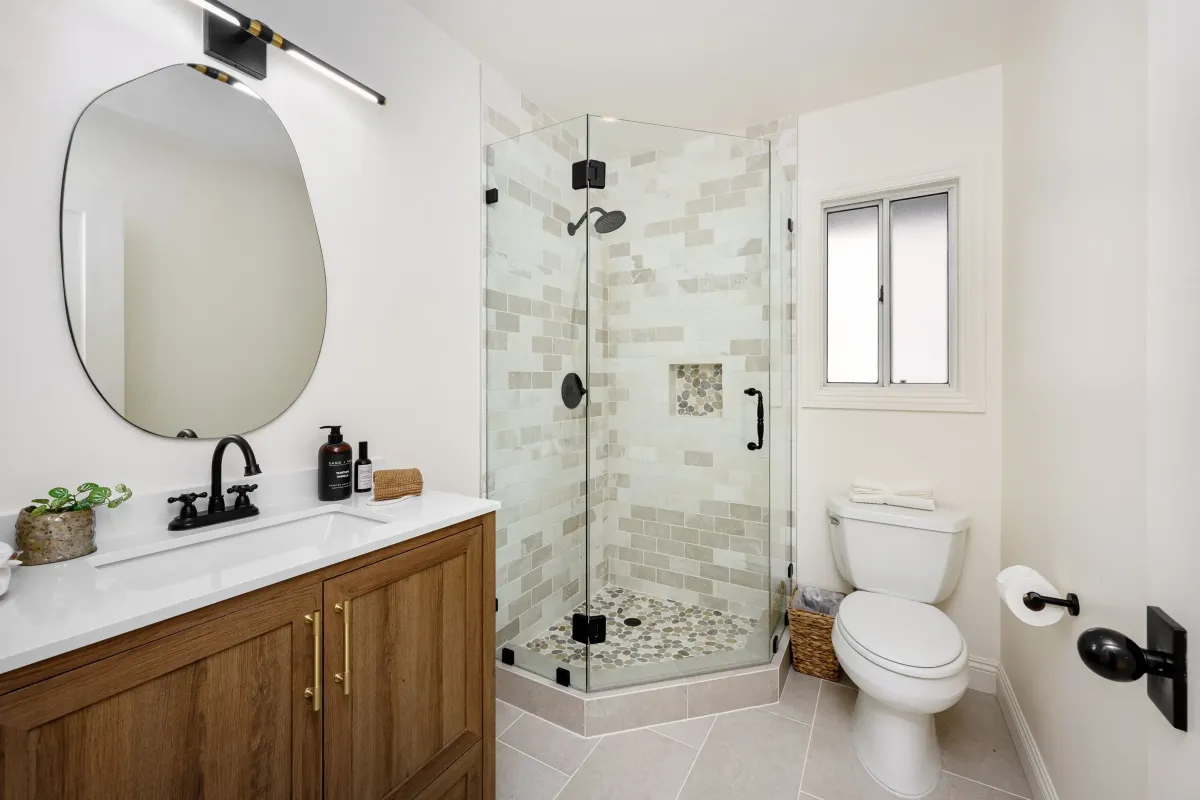 Contemporary bathroom remodel with glass shower, white tile, and wood vanity in St. Peters, MO