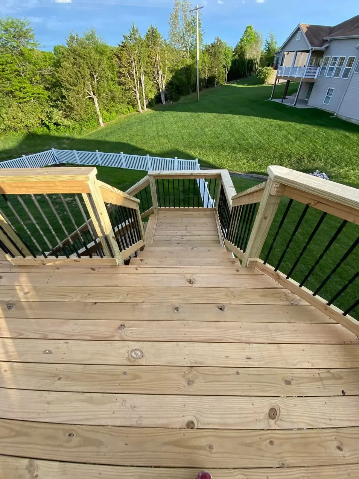 Angled deck railing installation in Cottleville, MO with modern vertical spindles.
