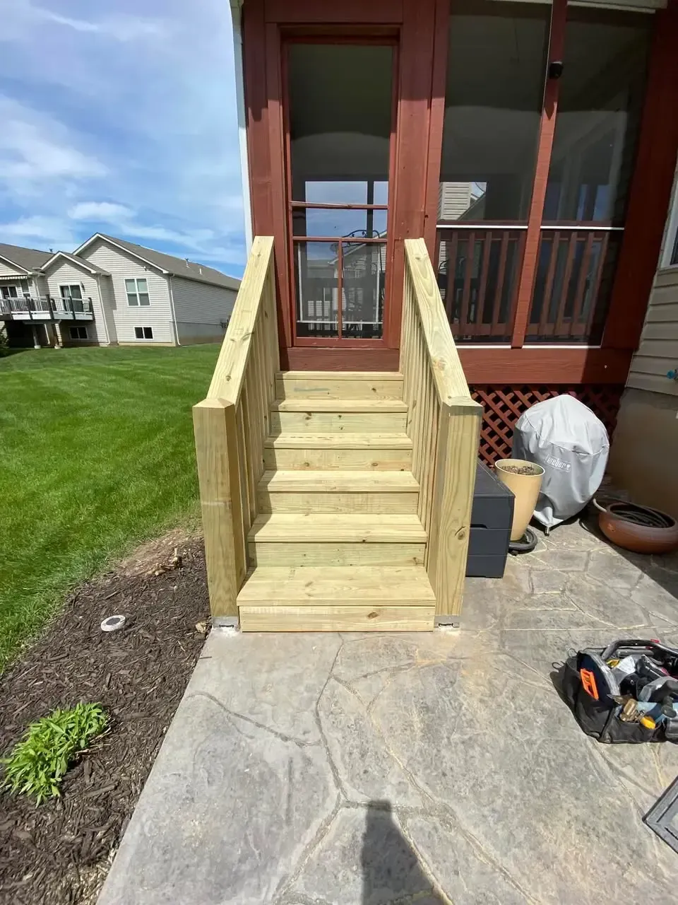 Close-up of the deck staining process in Cottleville, MO showing fresh lumber and prep work.