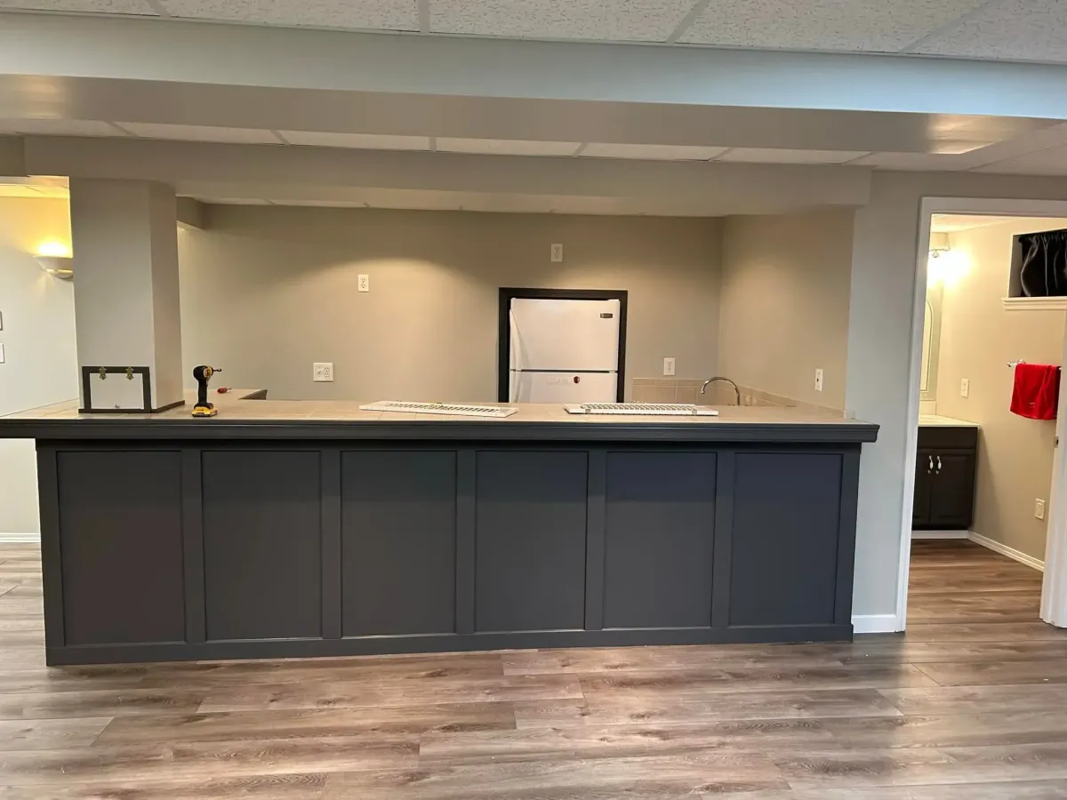 Open-space basement remodel in Lake St. Louis, MO – custom bar installation and modern lighting design.