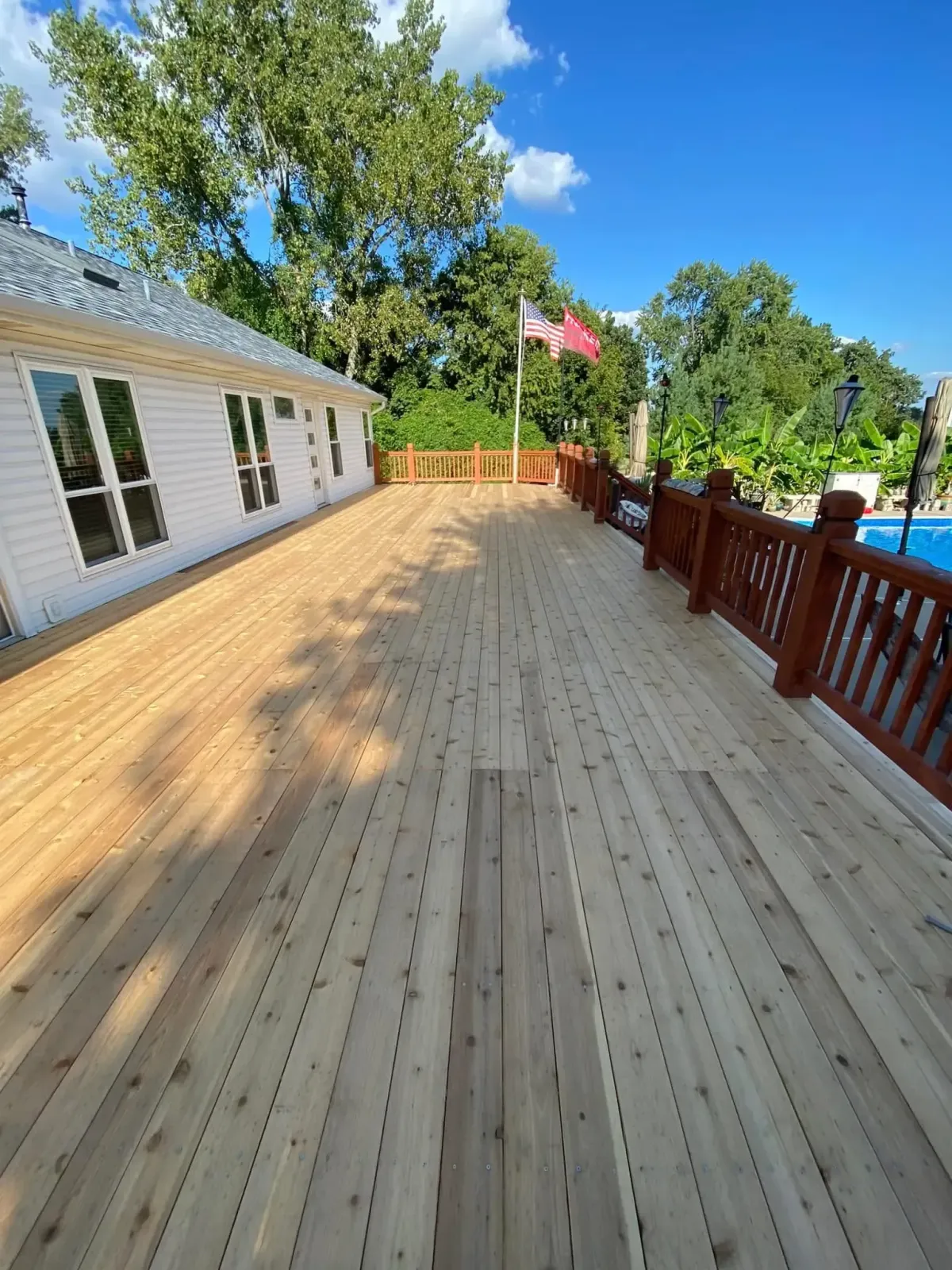 Large wood deck renovation with American flag theme in Lake St. Louis, MO – fresh planks and railing upgrade