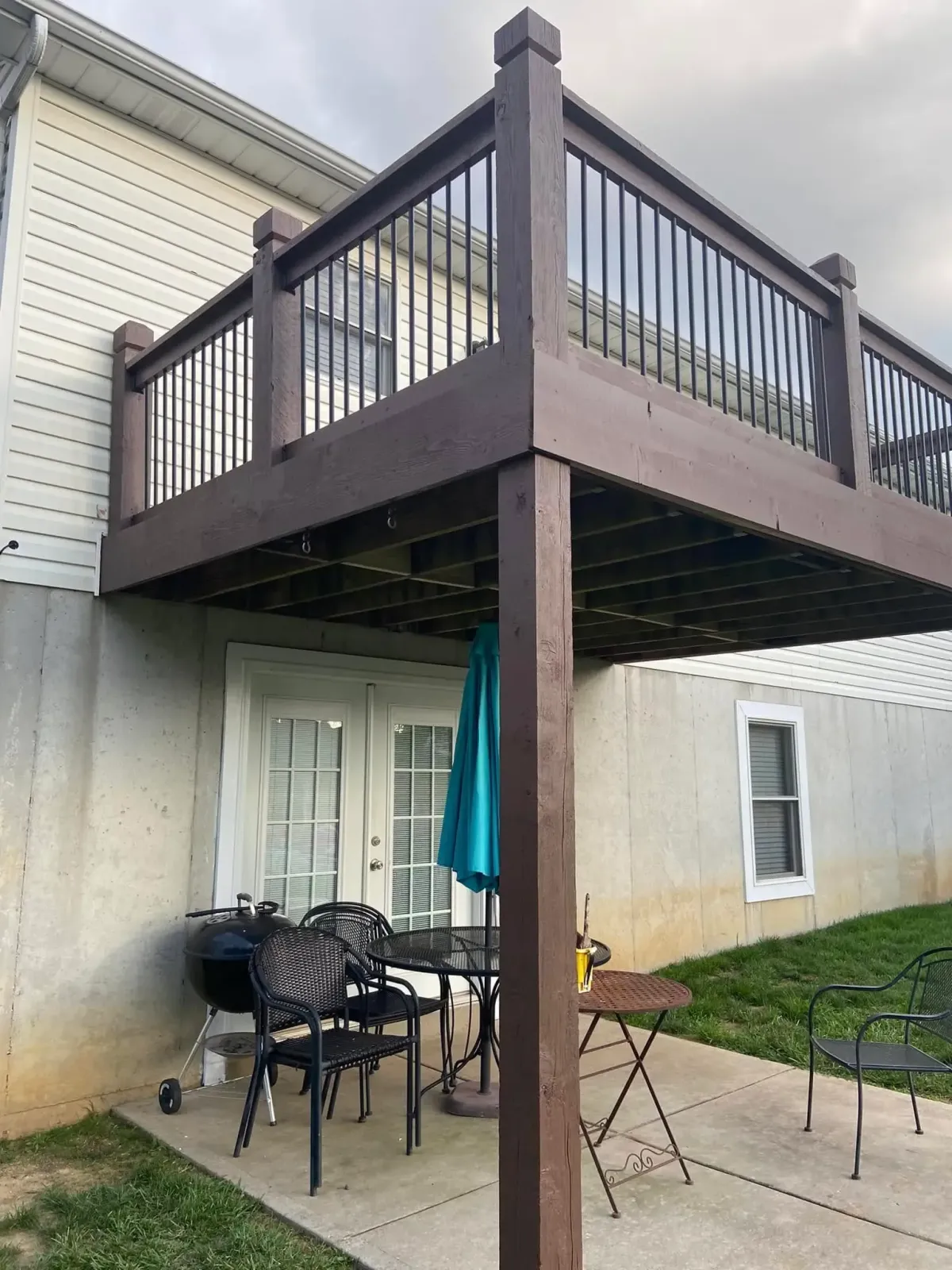 Elevated brown-tone backyard deck installation in Lake St. Louis, MO – composite railing and underdeck patio.