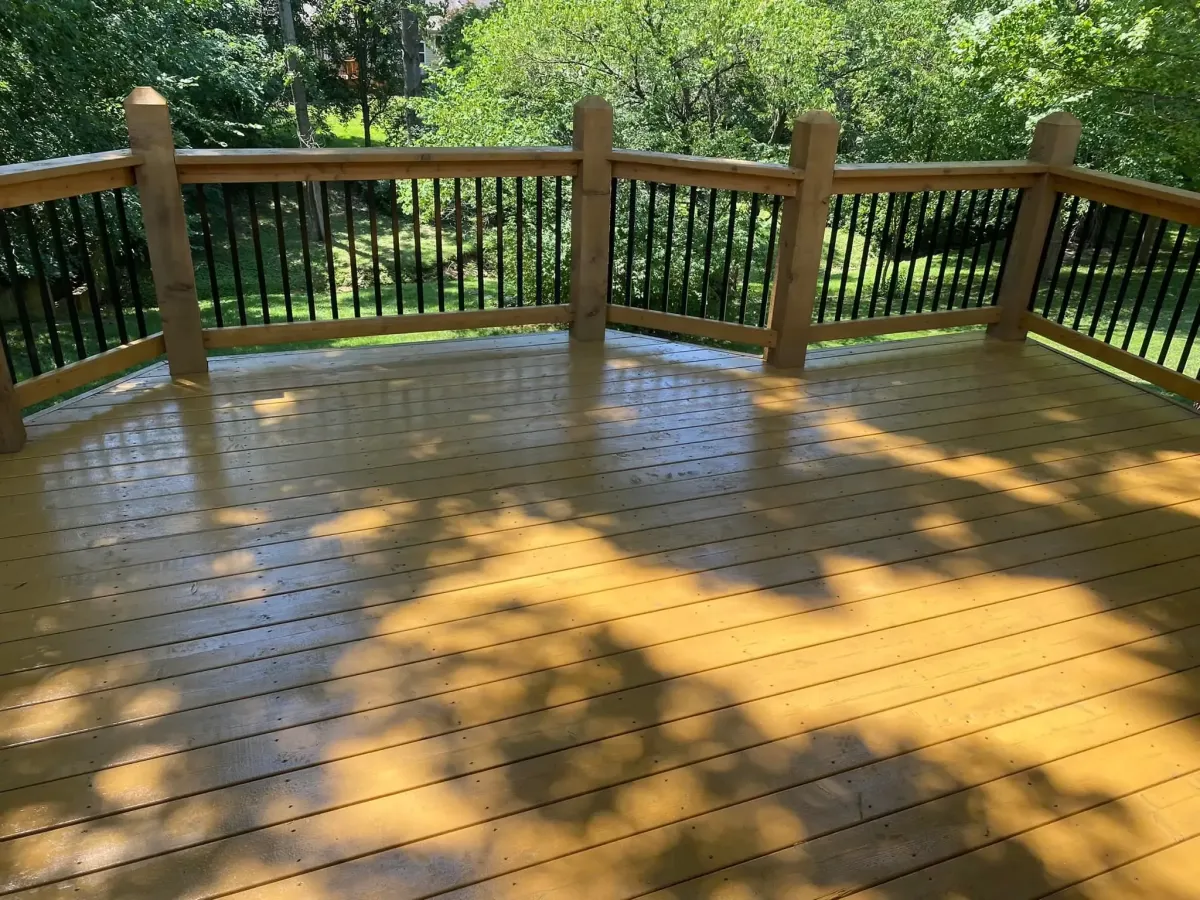 Backyard gazebo installation in St. Louis, MO featuring a screened wooden structure beside a landscaped area.