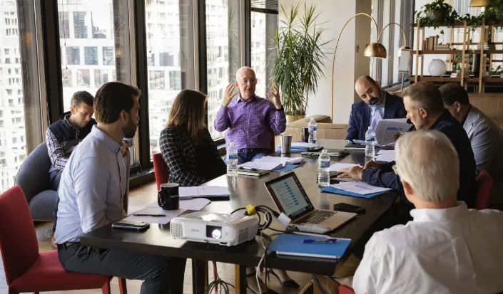 man sitting by the desk using laptop computer