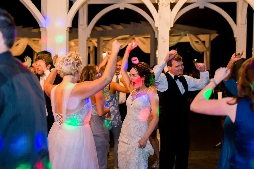Brides and guests dancing under colorful lights at Springfield MO wedding DJ reception