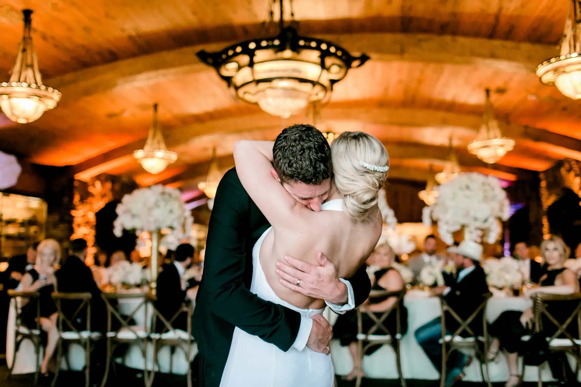 Bride and groom hugging during first dance at Springfield, MO wedding reception with DJ entertainment services