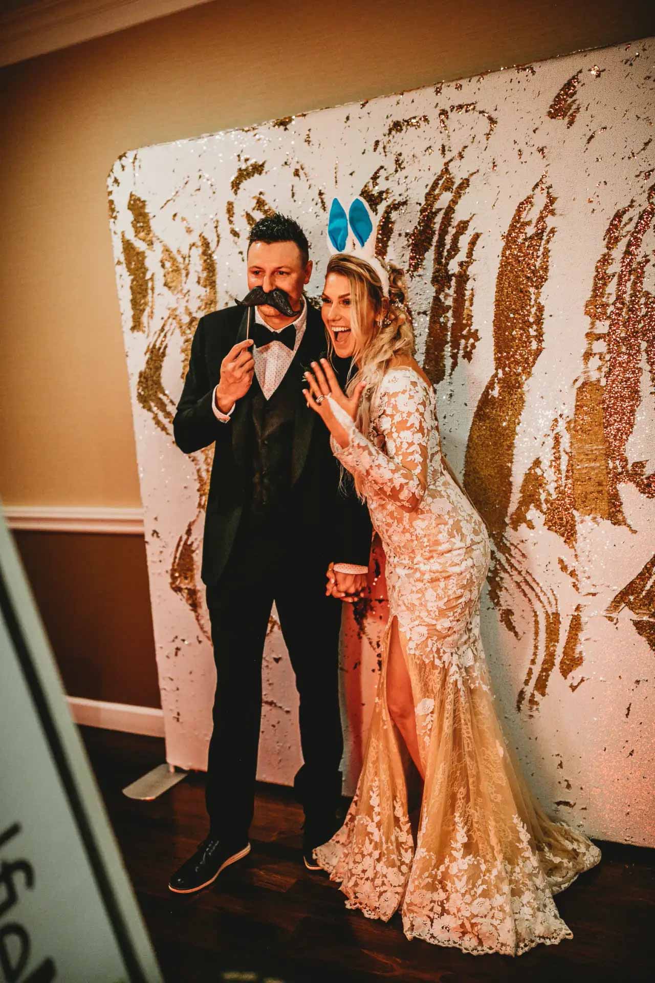 Bride and groom using fun props at wedding photo booth in Springfield MO