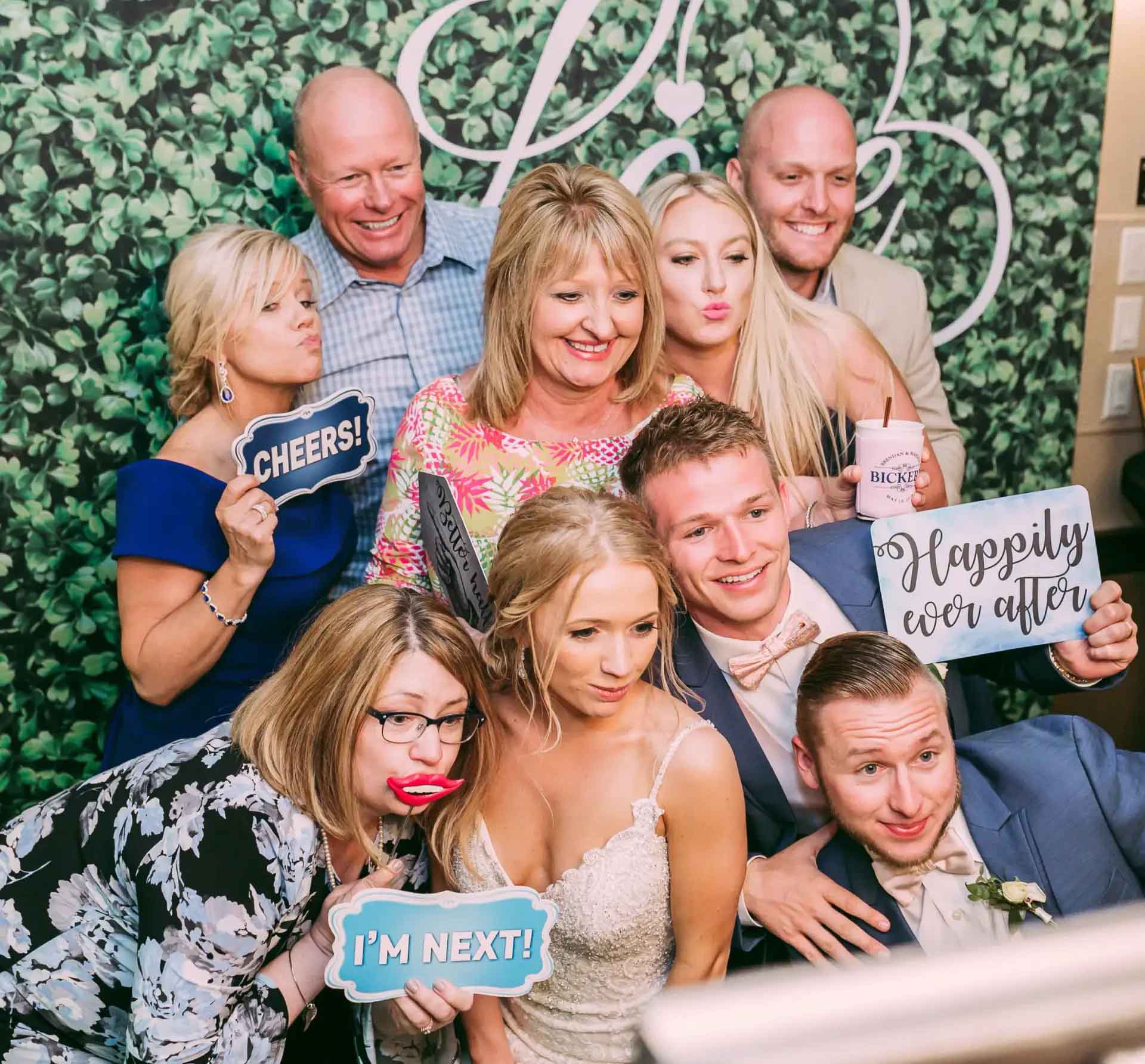 Springfield MO wedding photo booth with couple and guests holding fun props and signs