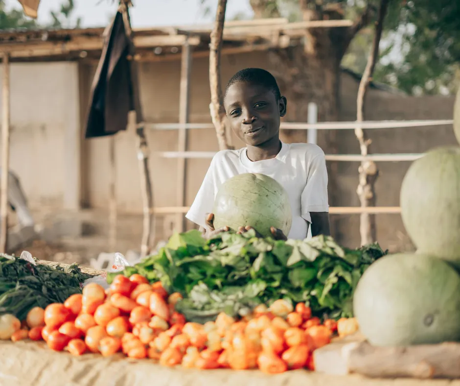Two people working with a laptop outside greenhouse