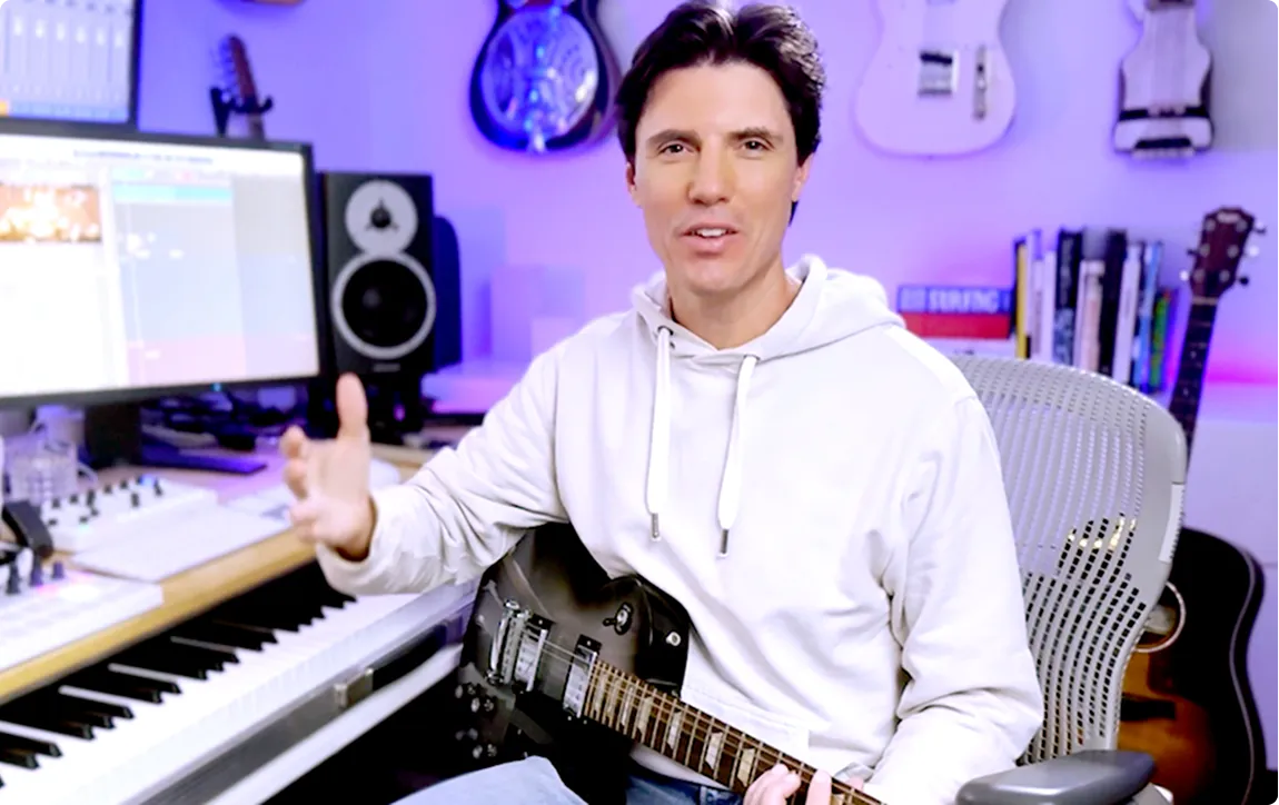 Film composer and engineer at professional recording console with musicians performing in studio