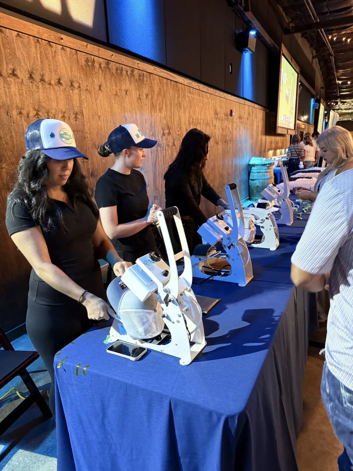 A creative workspace with a designer sketching unique branded merchandise concepts on a digital tablet, surrounded by color swatches and material samples. The setting is bright and professional, emphasizing customization and attention to detail.