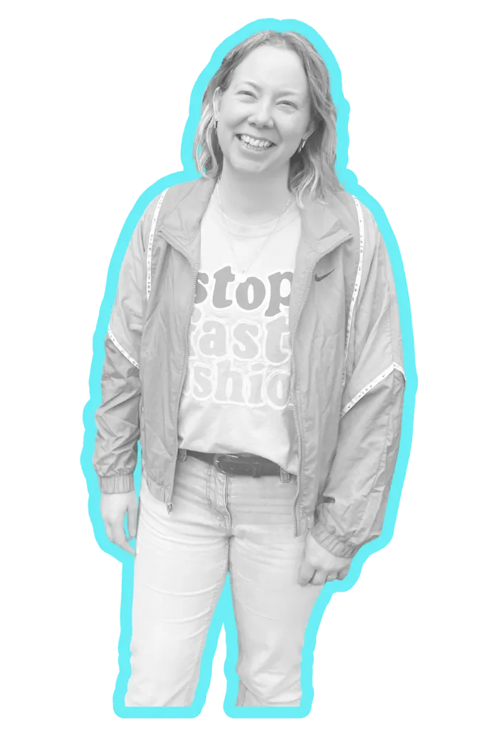 Black and white photo of Christina Poulton wearing a T shirt, jeans and shell suit jacket and smiling, outlined in bright blue
