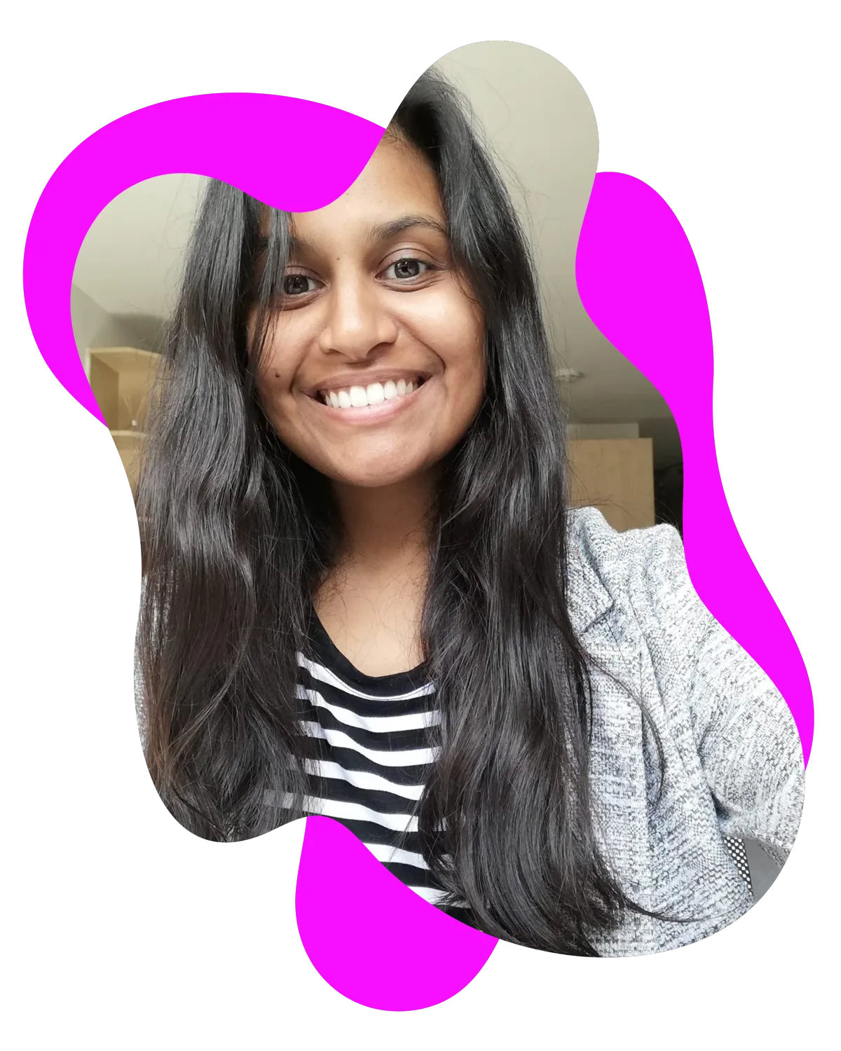 Taz from RadHR, smiling at the camera, with long dark hair, wearing a black and white striped top and grey cardigan.