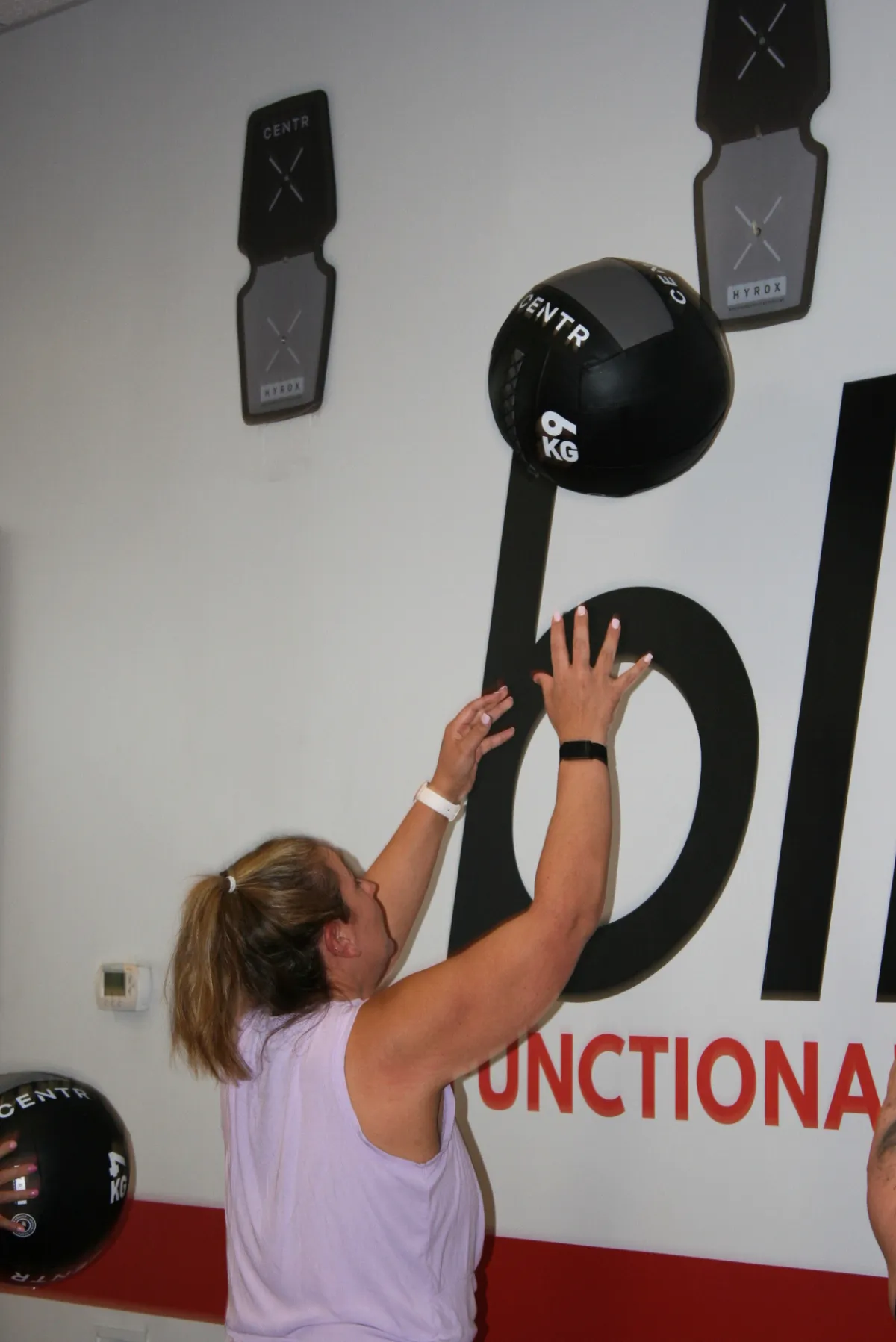 woman throwing medicine ball for wall balls