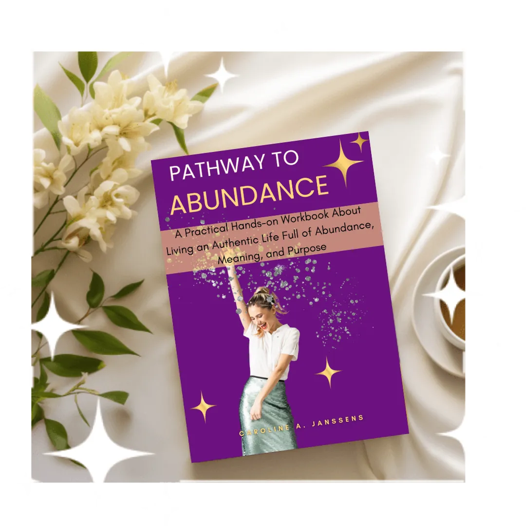 Pathway to Abundance" audiobook by Caroline A. Janssens displayed on a smartphone, supporting abundance mindset coaching, self-improvement, and personal growth through audio learning.