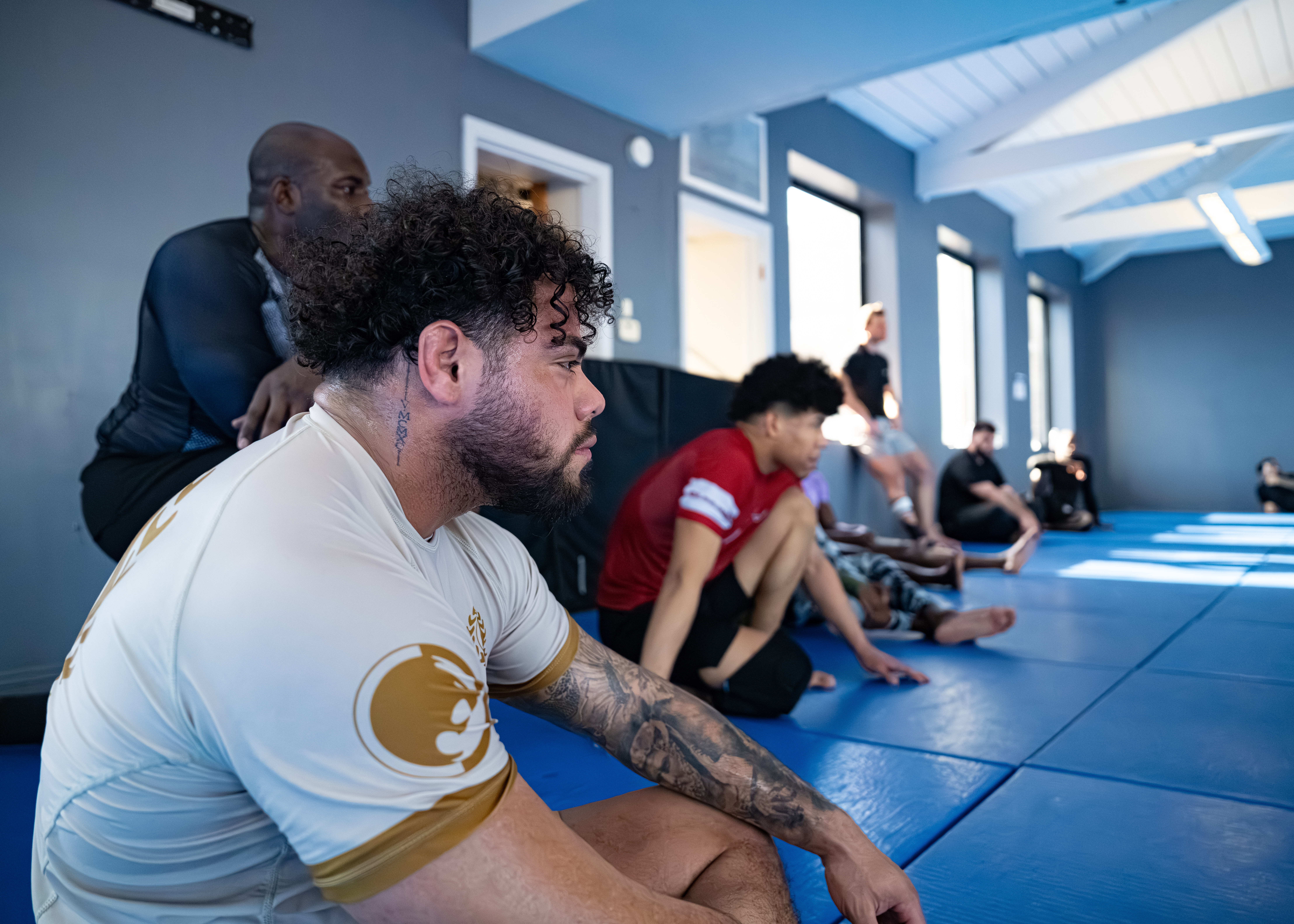 students lined up on the wall watching coaches explain moves of the day