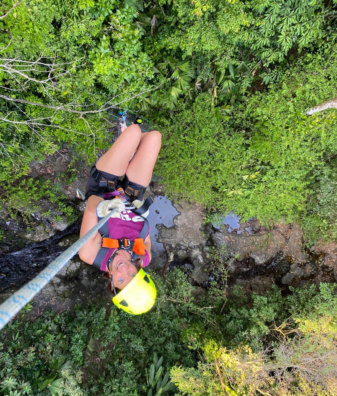 Kelee Love zip lining upside down through the jungle canopy in Costa Rica, embracing adventure and freedom